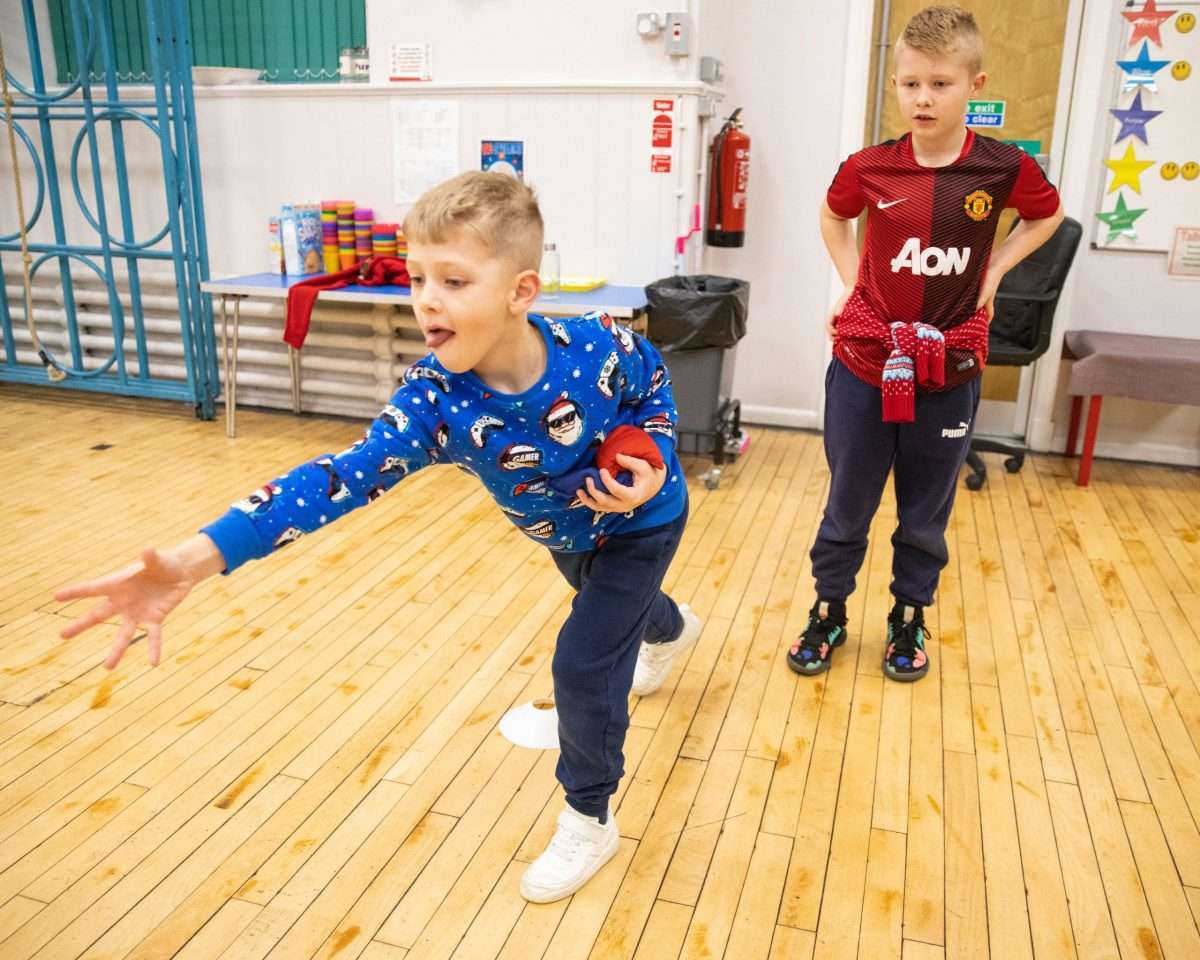two boys bowling inside