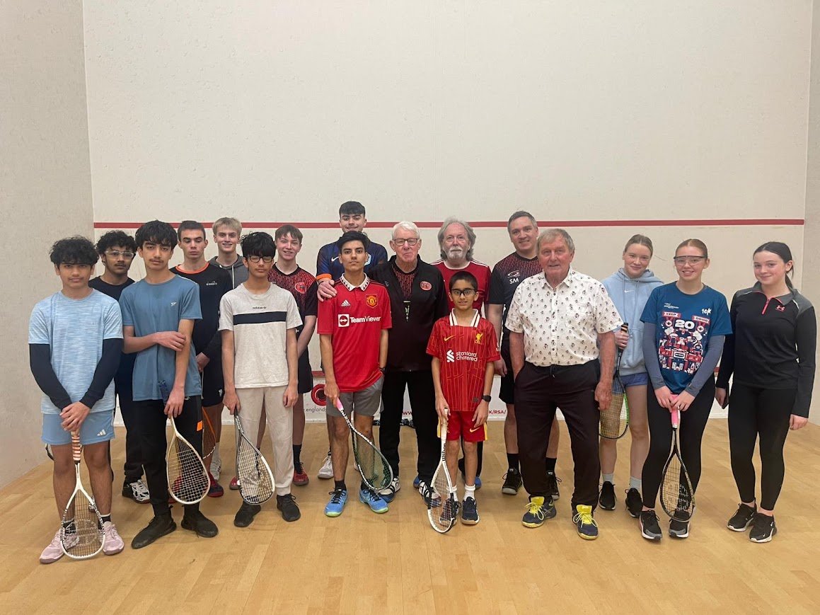 group picture of kids and adults in squash court